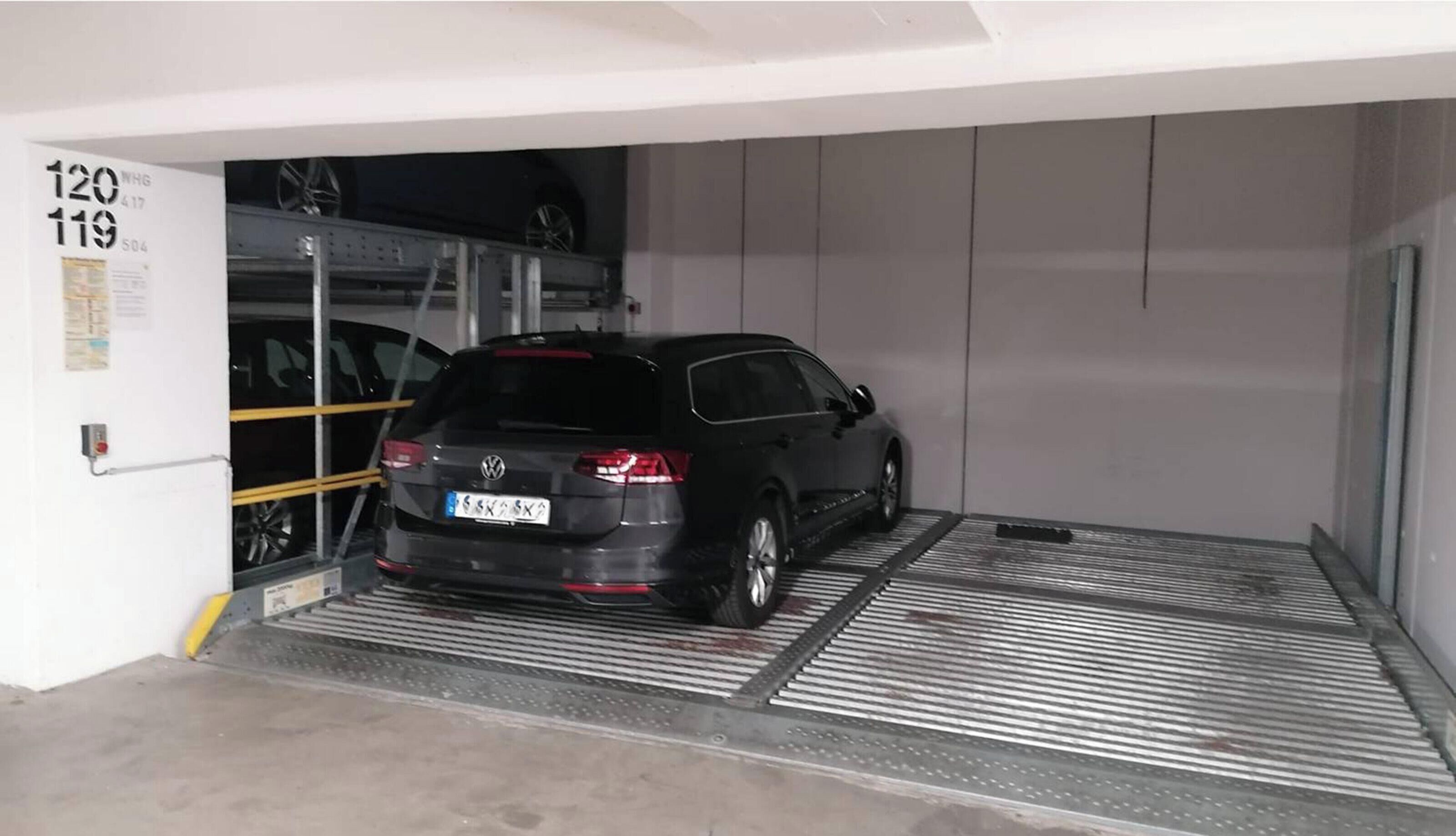 Een auto geparkeerd in een garage, met een helling naar de ingang.