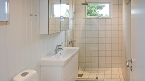 A bathroom with a white sink, mirror, and shower. - Nice home in Rudkøbing with WiFi (Rudkøbing)
