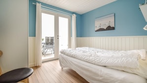 A bedroom with a bed, a chair, a window with curtains, and a painting on the wall. - Awesome home in Nyborg with WiFi (Nyborg)