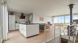 A modern kitchen with a central island, a dining area with a view, and a staircase leading to an upper level. - Awesome home in Nyborg with WiFi (Nyborg)