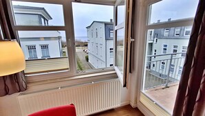 A room with a large window, a radiator, and a red chair. - Apartment Perlmuschel (A) - Villa Ahlbeck House 2 (Heringsdorf)