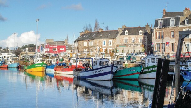 A harbor with various boats docked, buildings in the background, and a clear sky. - Lovely home in Le Faouet with kitchen (Le Faouet)