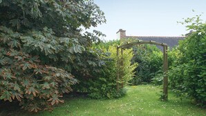 A garden with a wooden arbor and dense foliage. - Lovely home in Le Faouet with kitchen (Le Faouet)