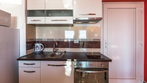 A modern kitchen with a stainless steel oven, a kettle, and a sink. - 2 bedroom beach front apartment in Makarska (Makarska)