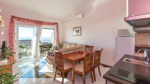 A compact living space with a dining area, kitchenette, and a balcony with a view. - 2 bedroom beach front apartment in Makarska (Makarska)