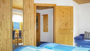 Une pièce avec un lit, un canapé bleu et une porte en bois.