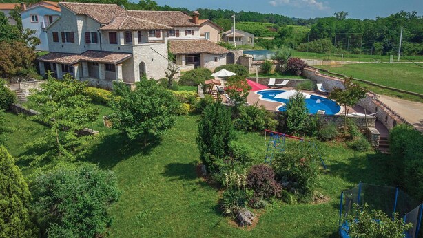 A large stone house with a swimming pool, surrounded by lush greenery and a tennis court. - Pet friendly home in Visnjan (Visnjan)