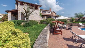 A stone house with a patio area, a swing chair, and a pool. - Pet friendly home in Visnjan (Visnjan)