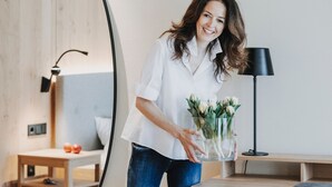 Une pièce avec un grand miroir, un bureau, une chaise et une lampe.