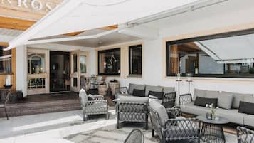 A hotel patio with wicker furniture, a sofa, and a table.