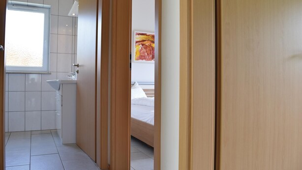 Una camera da letto moderna con un letto, una finestra e un quadro appeso al muro.