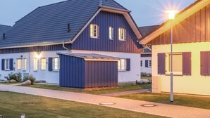 Una moderna casa a due piani con facciata blu scuro e tetto spiovente.