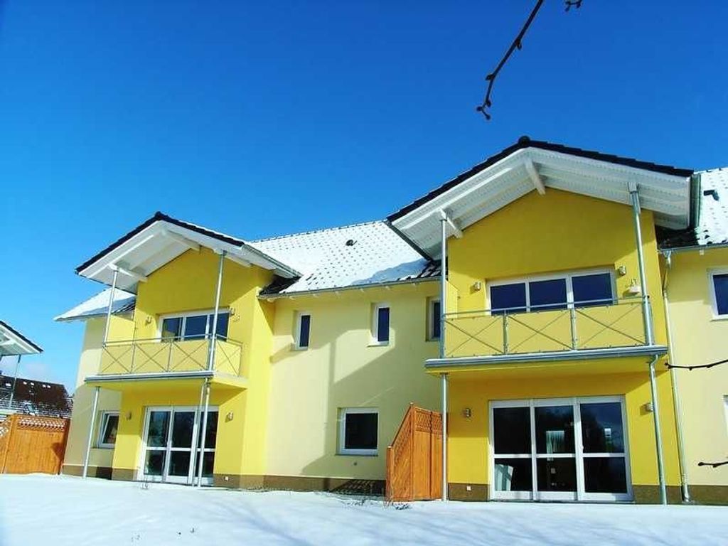 A yellow multi-story building with large windows and a flat roof.