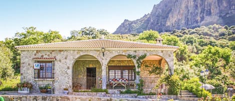 A stone building with a tiled roof, multiple arches, and a sign indicating a restaurant.