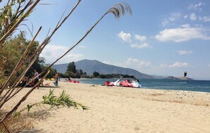 A beach with tents and a mountain in the background.