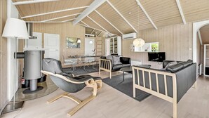Un interior moderno con comedor, asientos y televisor.