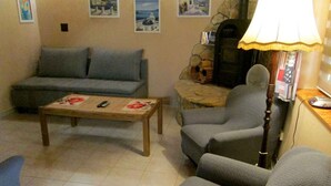 A living room with a sofa, armchairs, a coffee table, and a lamp. - Holiday home with terrace and barbecue (Balatonboglár)