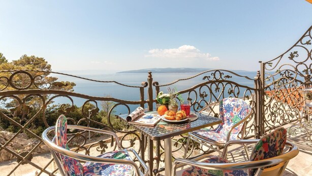 A terrace with metal chairs and a table, overlooking a scenic view of the sea and distant mountains. - Beautiful apartment in Krvavica (Krvavica)