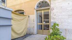 A building entrance with a beige awning, a glass door, and a small plant in the foreground. - Pet friendly apartment in Rapallo -GE- (Rapallo -GE-)