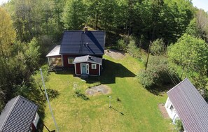 A single-story house with a dark roof, a red exterior, and a small front porch.