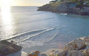 A coastal view with calm sea, rocky shoreline, and a building on a hill. - Amazing home in Tregunc with WiFi (Tregunc)