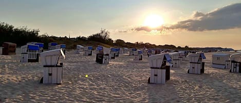 Una playa con filas de cabañas de playa.