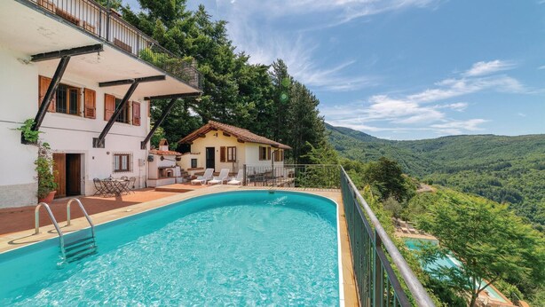 A poolside view of a villa with a pool, outdoor seating, and a scenic mountain backdrop. - Nice apartment in Loro Ciuffenna AR (Loro Ciuffenna AR)