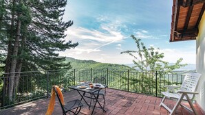 A terrace with a table set for two, overlooking a mountainous landscape. - Nice apartment in Loro Ciuffenna AR (Loro Ciuffenna AR)
