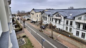 Une rue résidentielle bordée d’immeubles à plusieurs étages, avec une chaussée dégagée et un trottoir.