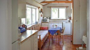 A compact kitchen with a bed, a dining table, and a small refrigerator. - Cozy home in Djurhamn with WiFi (Djurhamn)