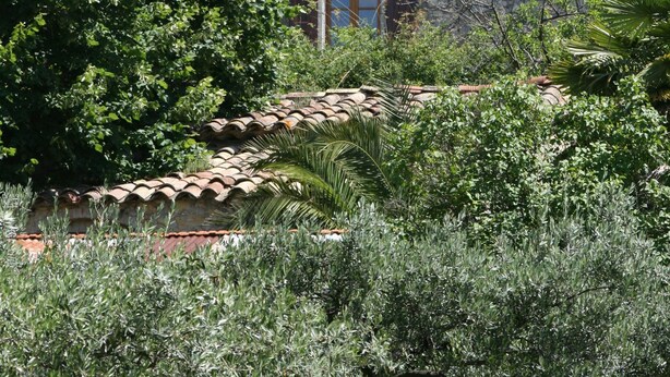 A stone building with a tiled roof, surrounded by greenery. - Tour Ourne Mas de Tours (Tornac)