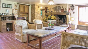 A rustic room with wicker furniture, a stone wall, and a fireplace. - Beautiful home in Monpazier (Monpazier)
