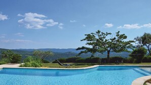 Ein Pool mit Blick auf Berge und einen Baum im Hintergrund.