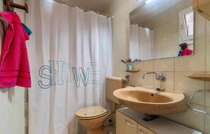 Ein Badezimmer mit Toilette, Waschbecken und Duschvorhang.