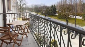 A balcony with a metal railing, a table, and chairs. - Zeromski (ZE05) - ZE05 (Swinoujscie)