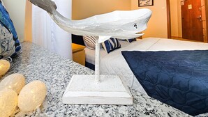 A room with a bed, a white whale sculpture on a stand, and a door in the background. - Zeromski (ZE05) - ZE05 (Swinoujscie)