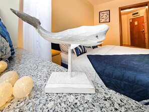 A room with a bed, a white whale sculpture on a stand, and a door in the background. - Zeromski (ZE05) - ZE05 (Swinoujscie)