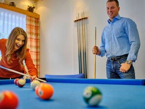 A pool table with balls and cues, a window with curtains, and a wall-mounted rack. - Single Room - Hotel Winterberg (Bad Harzburg)