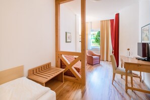 A room with a bed, a desk, a chair, and a television. - Single Room - Hotel Winterberg (Bad Harzburg)