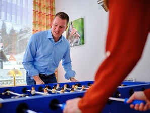 A person playing foosball with another individual.