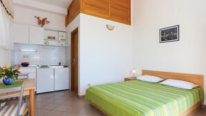 A compact hotel room with a bed, a small kitchenette, and a dining area. - Nice apartment in Omis with WiFi (Omis)