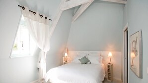 A bedroom with a bed, two bedside tables with lamps, a window with a white curtain, and a framed picture on the wall. - Stunning home in Coly with WiFi (Coly)