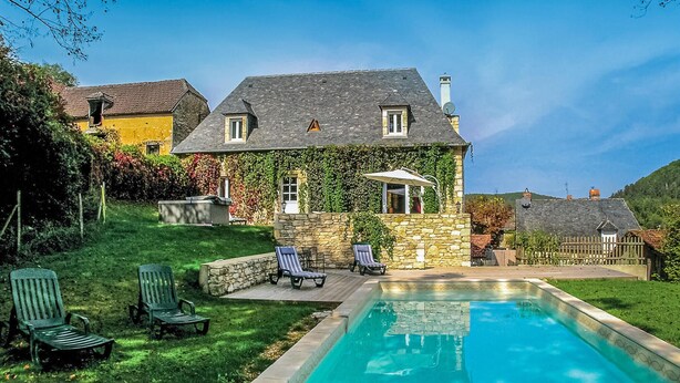 A house with a swimming pool, stone walls, and a garden with chairs. - Stunning home in Coly with WiFi (Coly)