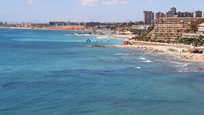 A coastal cityscape with a beach, buildings, and clear blue waters. - 2 bedroom beautiful home in La Florida (La Florida)