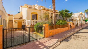 A residential street with houses featuring balconies, palm trees, and a gated entrance. - 2 bedroom beautiful home in La Florida (La Florida)