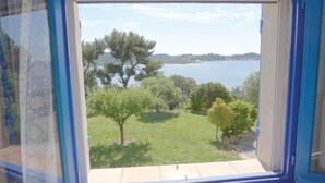 A window view of a grassy area with trees and a body of water. - Stunning apartment in ISTRES with WiFi (ISTRES)
