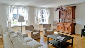 A living room with a sofa, armchairs, a coffee table, and a cabinet. - Apartment 2 - large apartments in the Manor House (Weitendorf)