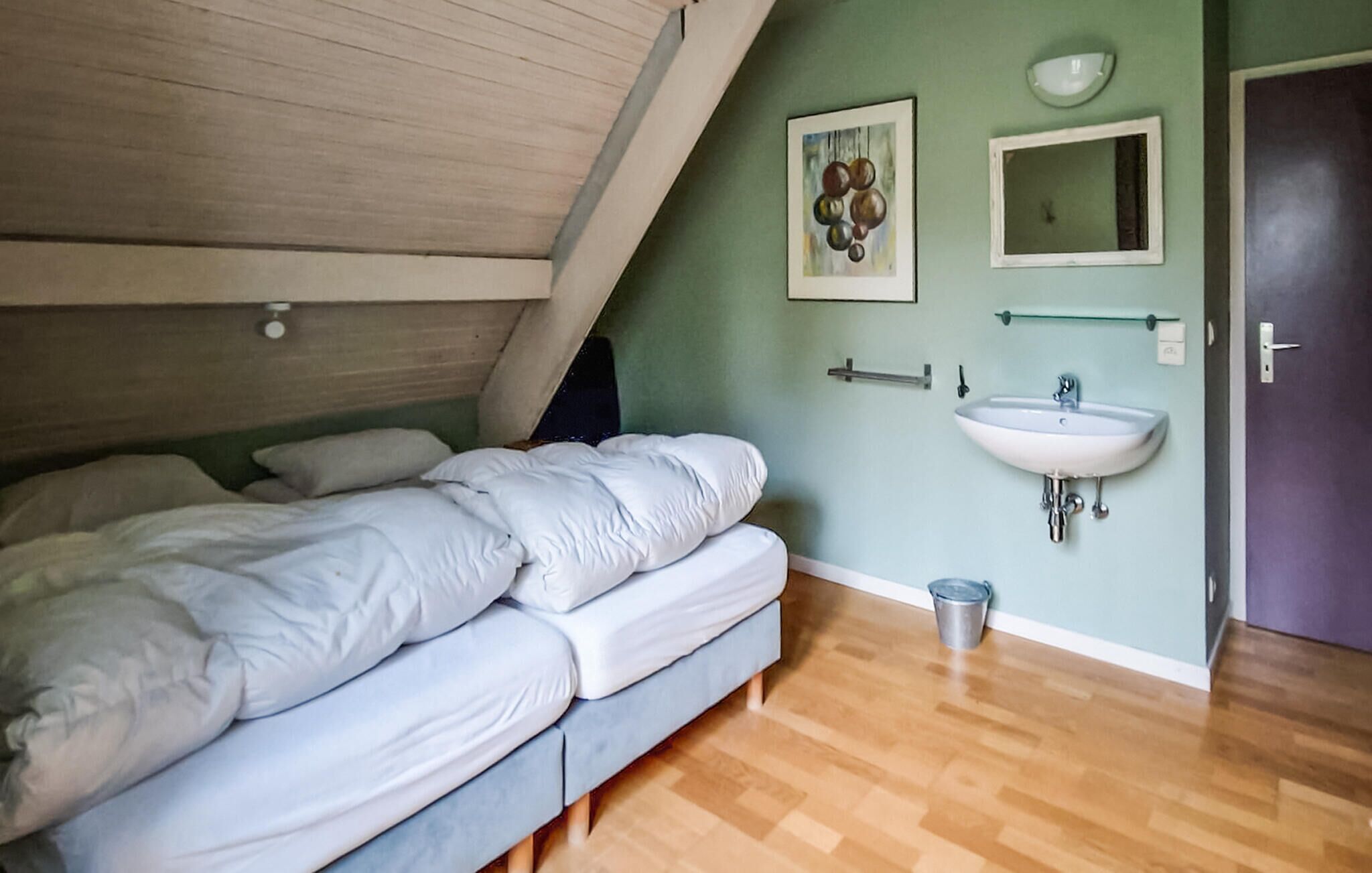 A bedroom with a bunk bed, a sink, and a mirror.