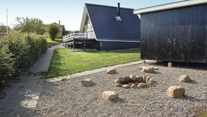 Ein Gebäude mit einem geneigten Dach, einem Kiesgrund mit Steinen und einem Weg, der zu einem Haus führt.
