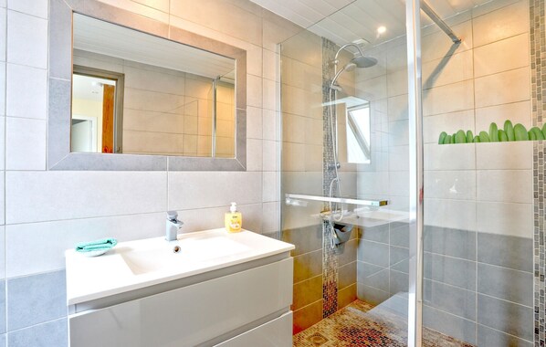 A modern bathroom with a white sink, mirror, and shower. - 3 bedroom amazing home in Vergoncey (Vergoncey)